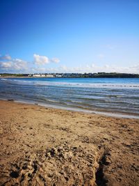 Scenic view of beach against blue sky