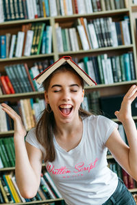 Close-up of smiling girl with book at library