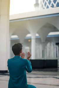 Rear view of man standing in mosque