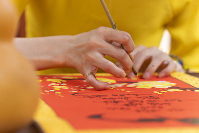 Midsection of woman writing on greeting