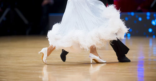 Low section of people dancing on hardwood floor