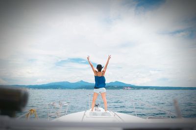 Woman standing on boat over sea against sky