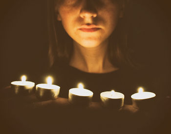 Close-up of lit candles in the dark