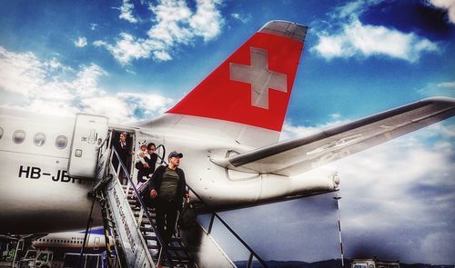 Low angle view of man on airplane against sky