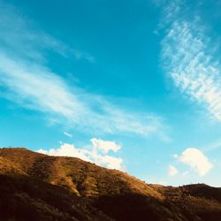 Low angle view of mountain against blue sky