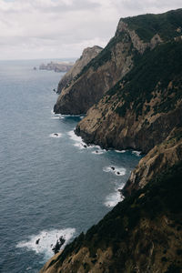Scenic view of sea and mountains against sky