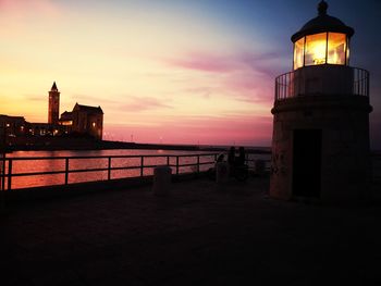 View of lighthouse by sea against sky during sunset
