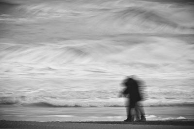 Blurred motion of woman standing on beach