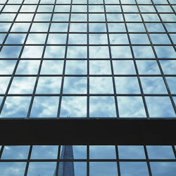 Low angle view of glass building against sky