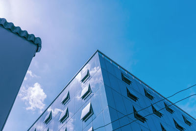 Looking up at the angle of modern business buildings in the city with blue tone and brighten sky