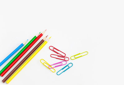 High angle view of colored pencils against white background