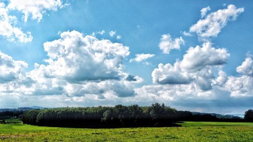 Scenic view of field against cloudy sky