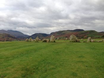 Scenic view of rocks on mountains against cloudy sky