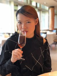 Portrait of woman drinking champagne in restaurant