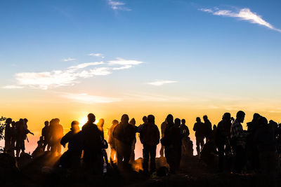 Silhouette people against sky during sunset