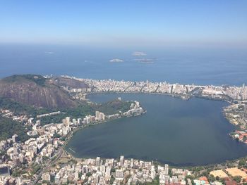 High angle view of town by sea against sky