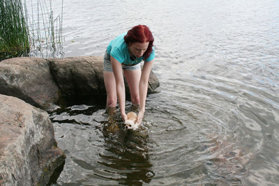 Full length of boy on rock in lake