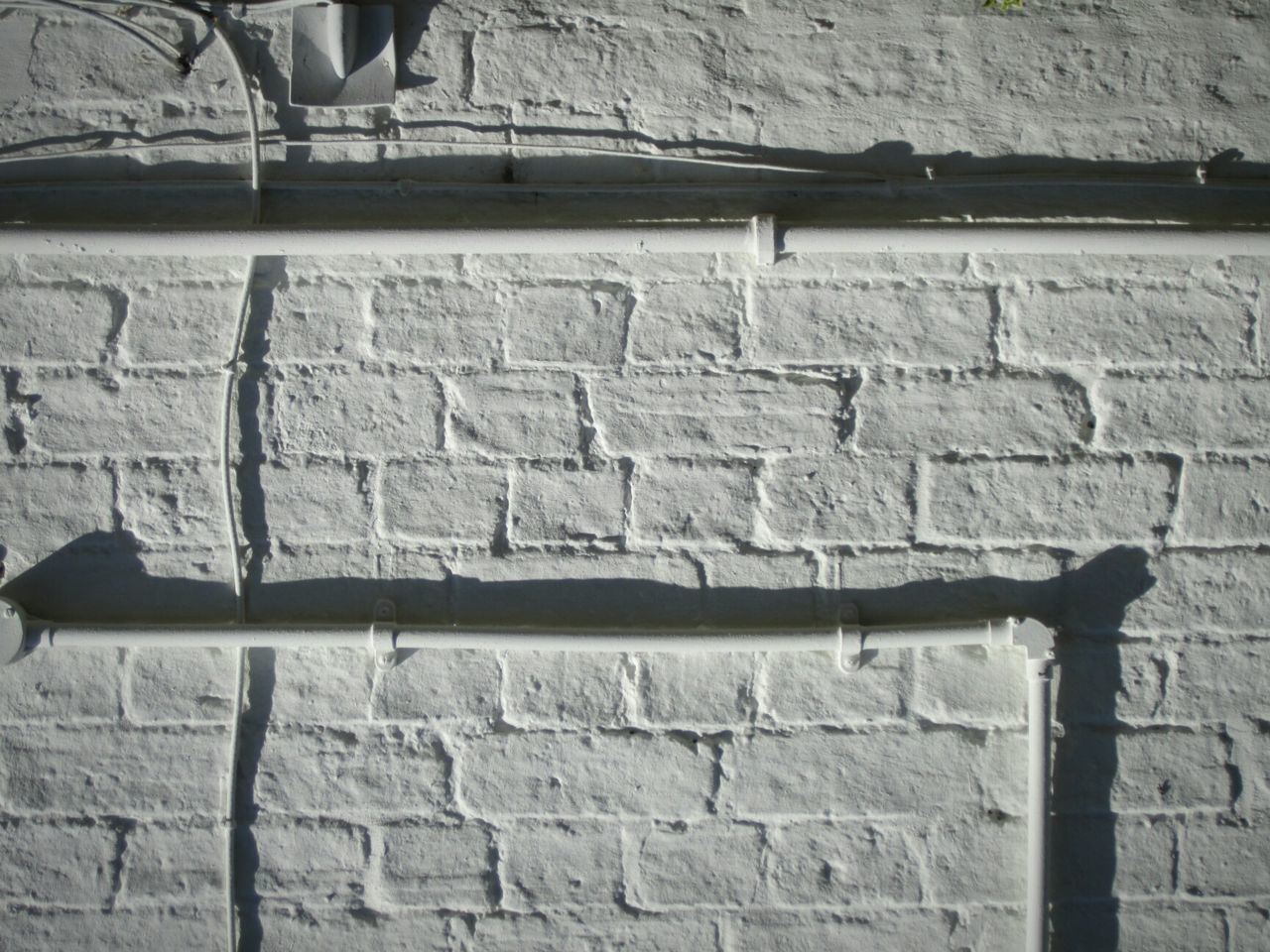 CLOSE-UP OF BRICK WALL WITH METAL STRUCTURE