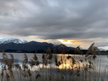 Scenic view of lake and mountains against sky during sunset