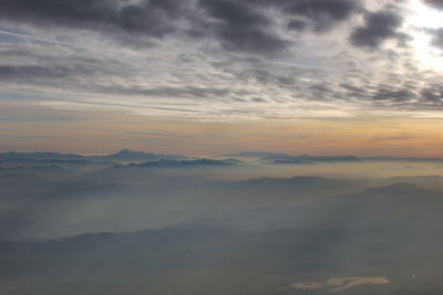 View of calm sea against cloudy sky during sunset