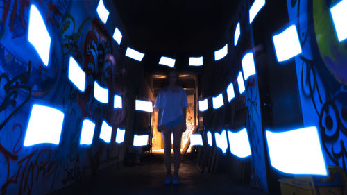 Man standing in illuminated corridor