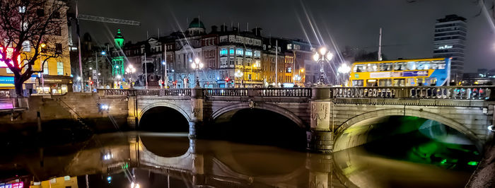 Bridge over river in city at night