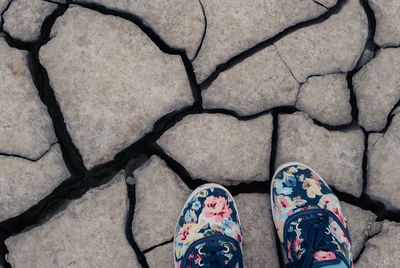 High angle view of shoes on cracked rock