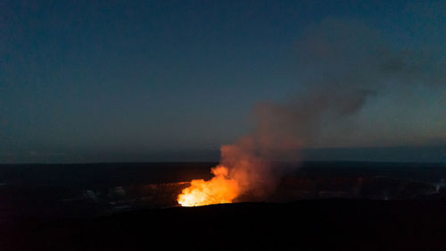 Bonfire in sea against sky at night