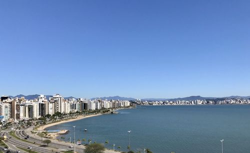 High angle view of city buildings against clear blue sky