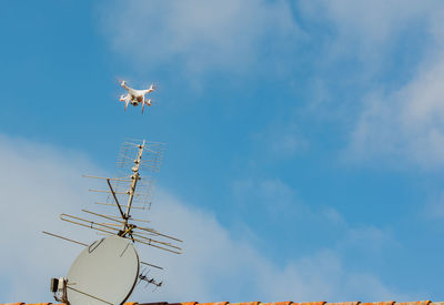 Low angle view of drone flying against sky