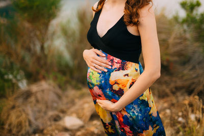 Midsection of woman standing on field