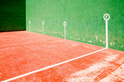 View of empty road against green wall