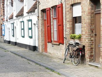 Bicycle parked on street amidst buildings