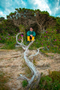 Man and plants on land against trees