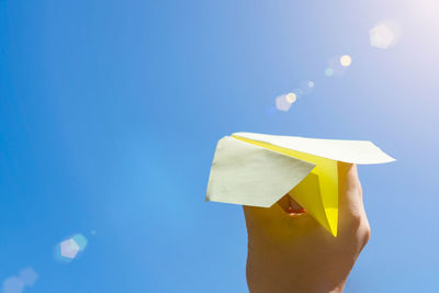 People launch paper airplane into clear sky