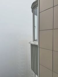 Buildings in city seen through window during winter