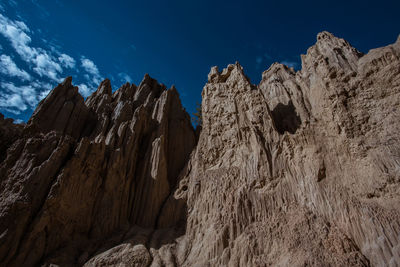 Low angle view of rocky mountains against sky