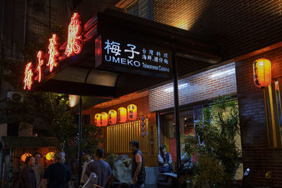 Low angle view of text on illuminated building at night