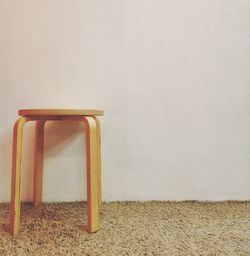 Empty chair against white wall at home