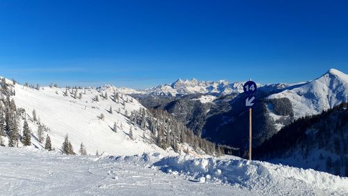 Scenic view of snowcapped mountains against clear blue sky