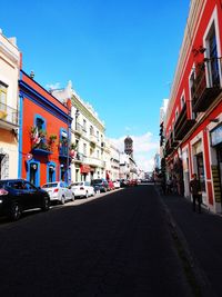 City street by buildings against sky