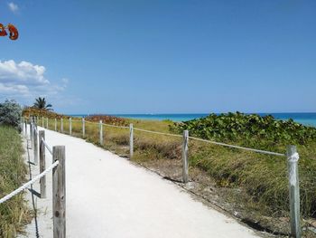 Fence on beach against sky