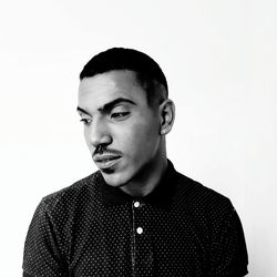 Young man looking away against white background