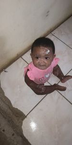 High angle portrait of cute girl with pink petals on floor