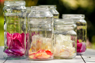 Rose petals in glass jars on table