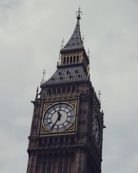 Low angle view of clock tower against cloudy sky