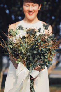 Portrait of smiling boy holding plant