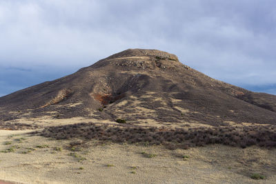 Low angle view of mountain against cloudy sky