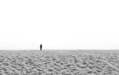 Man on beach against clear sky