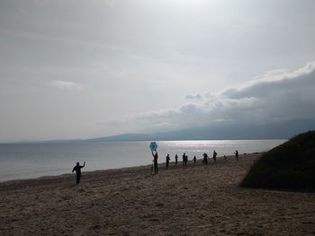 People on beach against sky